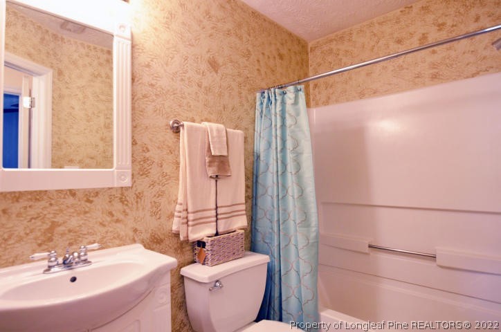 526 Riverwind Drive Spring Lake, NC 28390 - Photo 24 of 29 a bathroom with a sink and mirror with bathtub
