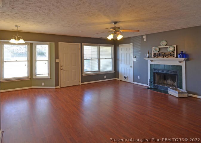526 Riverwind Drive Spring Lake, NC 28390 - Photo 8 of 29 an empty room with wooden floor fireplace and windows