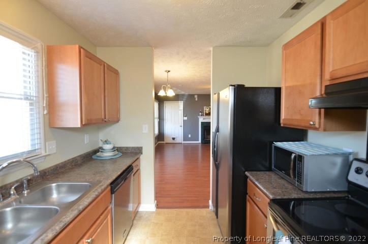 526 Riverwind Drive Spring Lake, NC 28390 - Photo 10 of 29 a kitchen with stainless steel appliances granite countertop a sink a refrigerator and a granite counter tops with white cabinets