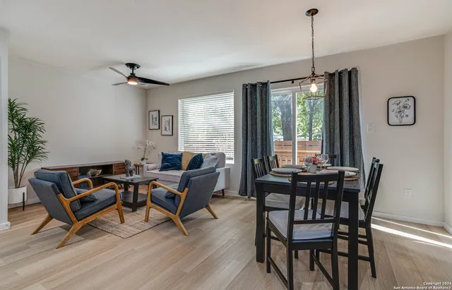 a dining room with furniture a chandelier and wooden floor