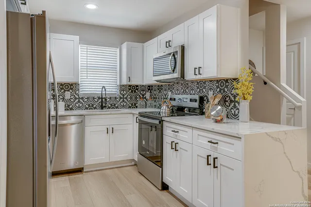 a kitchen with white cabinets and white appliances