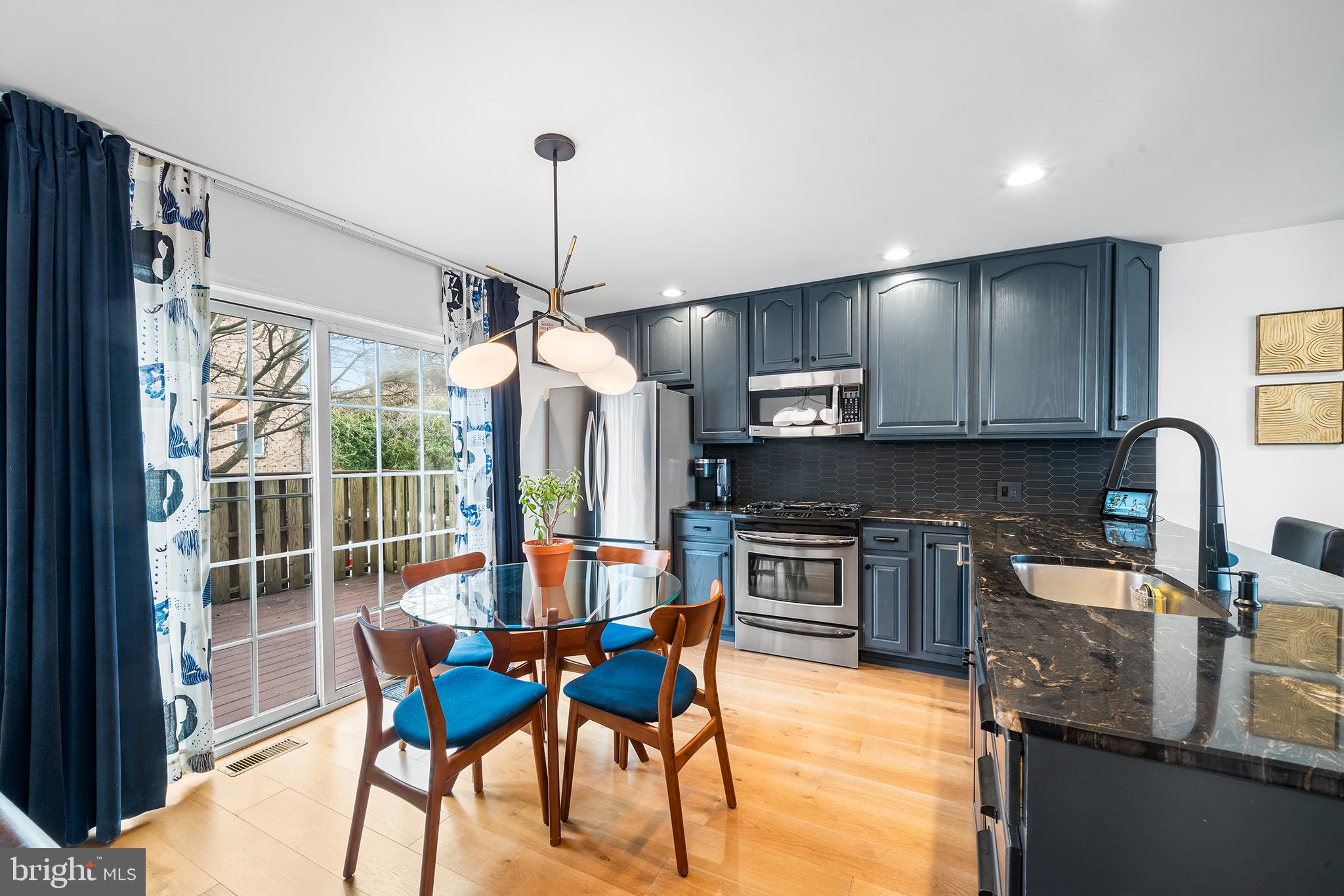 243 Ripka Street Philadelphia, PA 19127 - Photo 4 of 31 a kitchen with stainless steel appliances granite countertop a stove top oven a sink dishwasher a dining table and chairs with wooden floor
