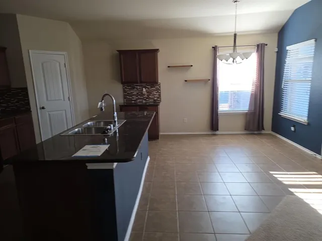 a kitchen with granite countertop a stove and a refrigerator