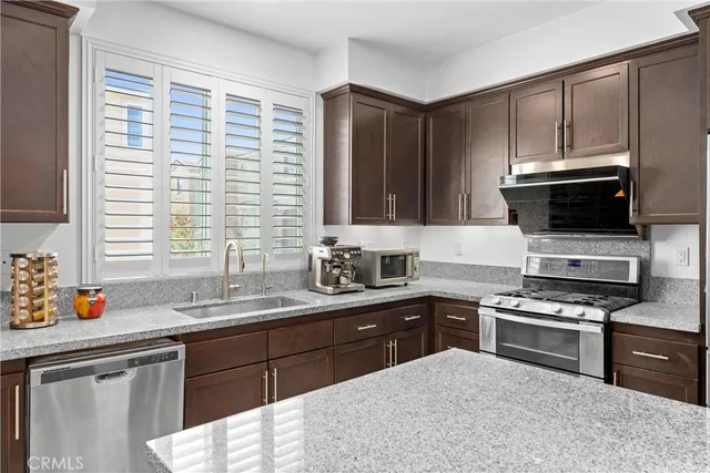 a kitchen with stainless steel appliances a stove sink microwave and cabinets