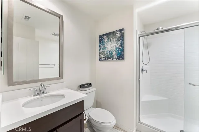 a bathroom with a granite countertop sink toilet a mirror a vanity and shower