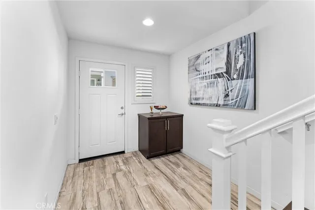 a view of a hallway with wooden floor and a window