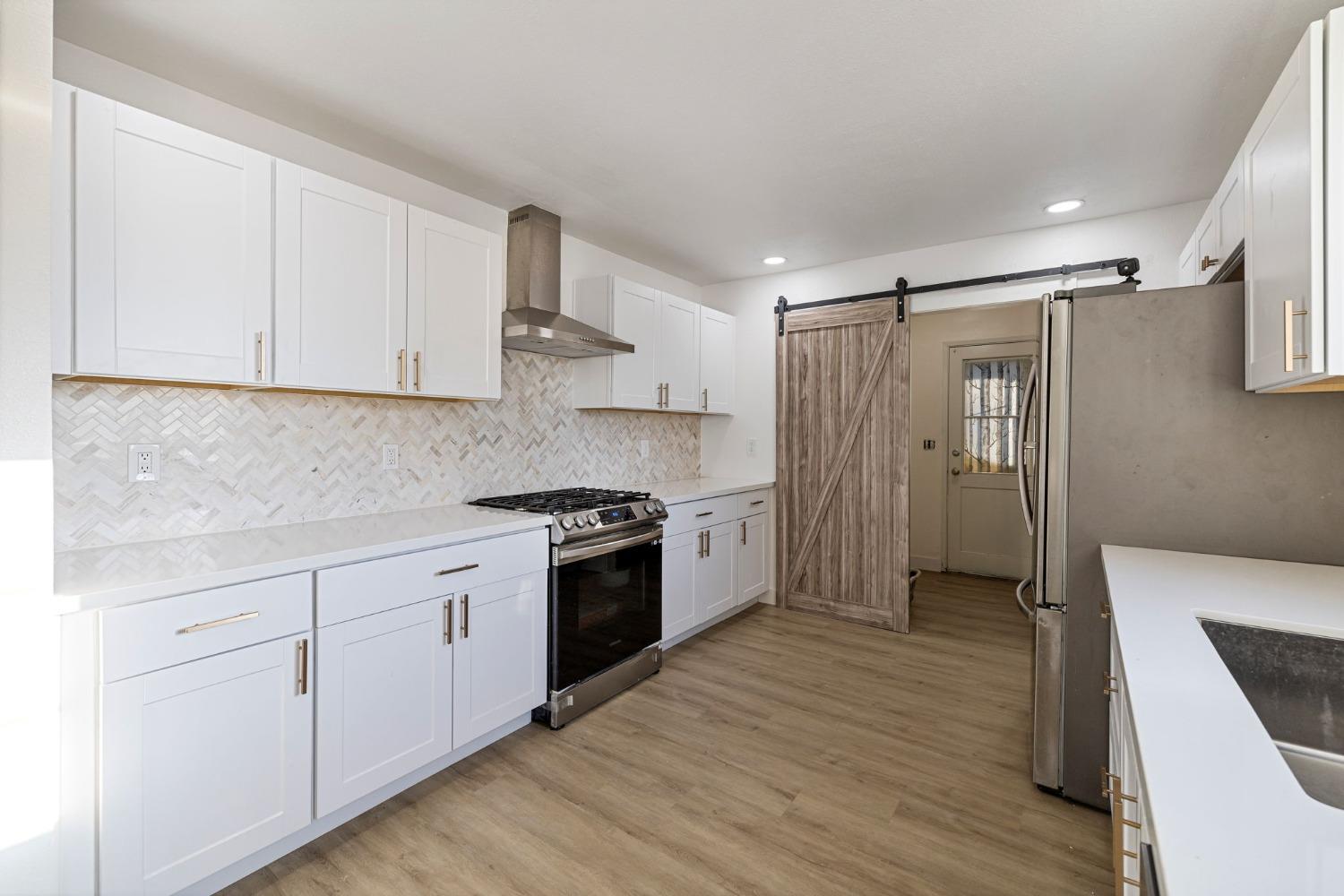 784 Sunnyside Avenue Clovis, CA 93611 - Photo 9 of 28 a kitchen with white cabinets and stainless steel appliances