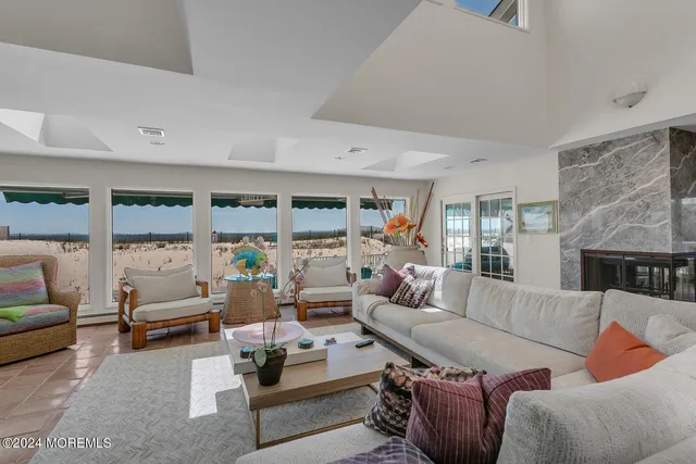 a living room with fireplace furniture and a large window