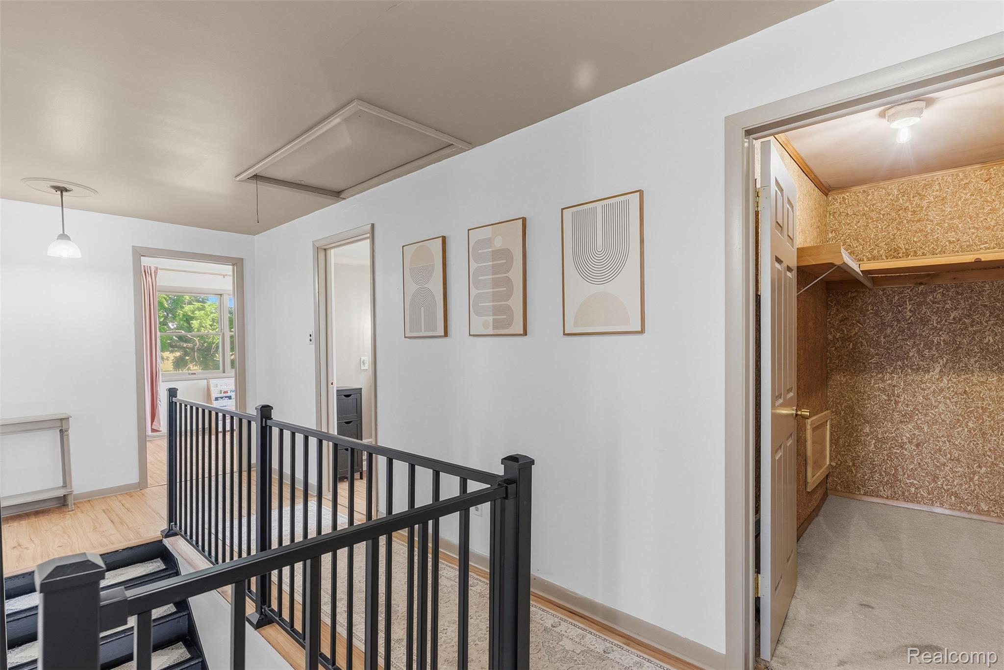 5843 West Dewey Road Owosso, MI 48867 - Photo 26 of 58 Hallway featuring light wood-finish flooring, a contemporary black metal railing, and white walls with neutral trim