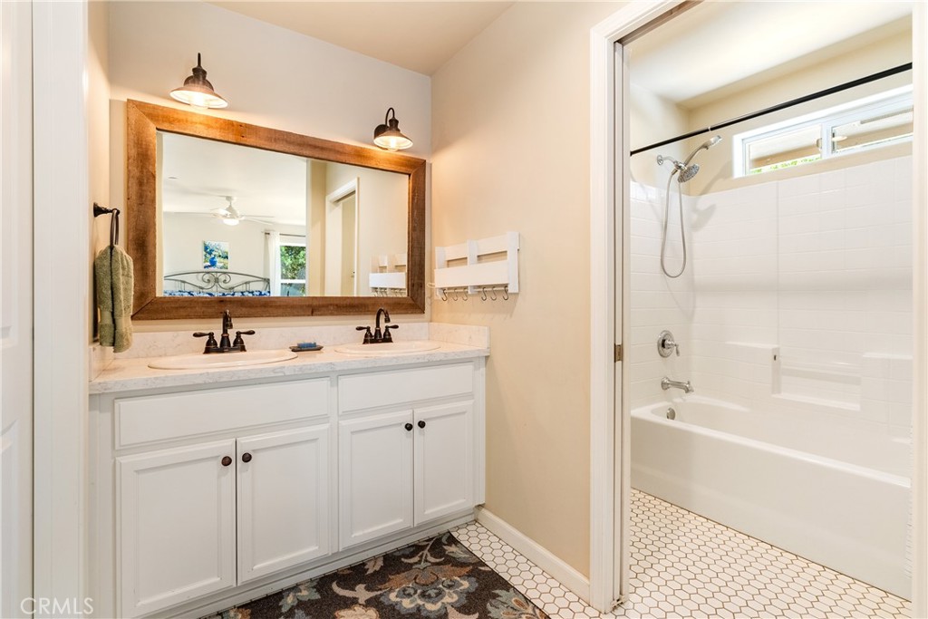 10825 Colorado Road Atascadero, CA 93422 - Photo 19 of 35 a bathroom with a double vanity sink and mirror with bathtub