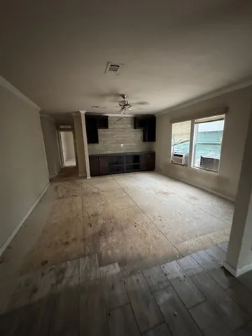 a view of an empty room with a fireplace and a window