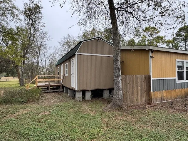a backyard of a house with barbeque oven and swing