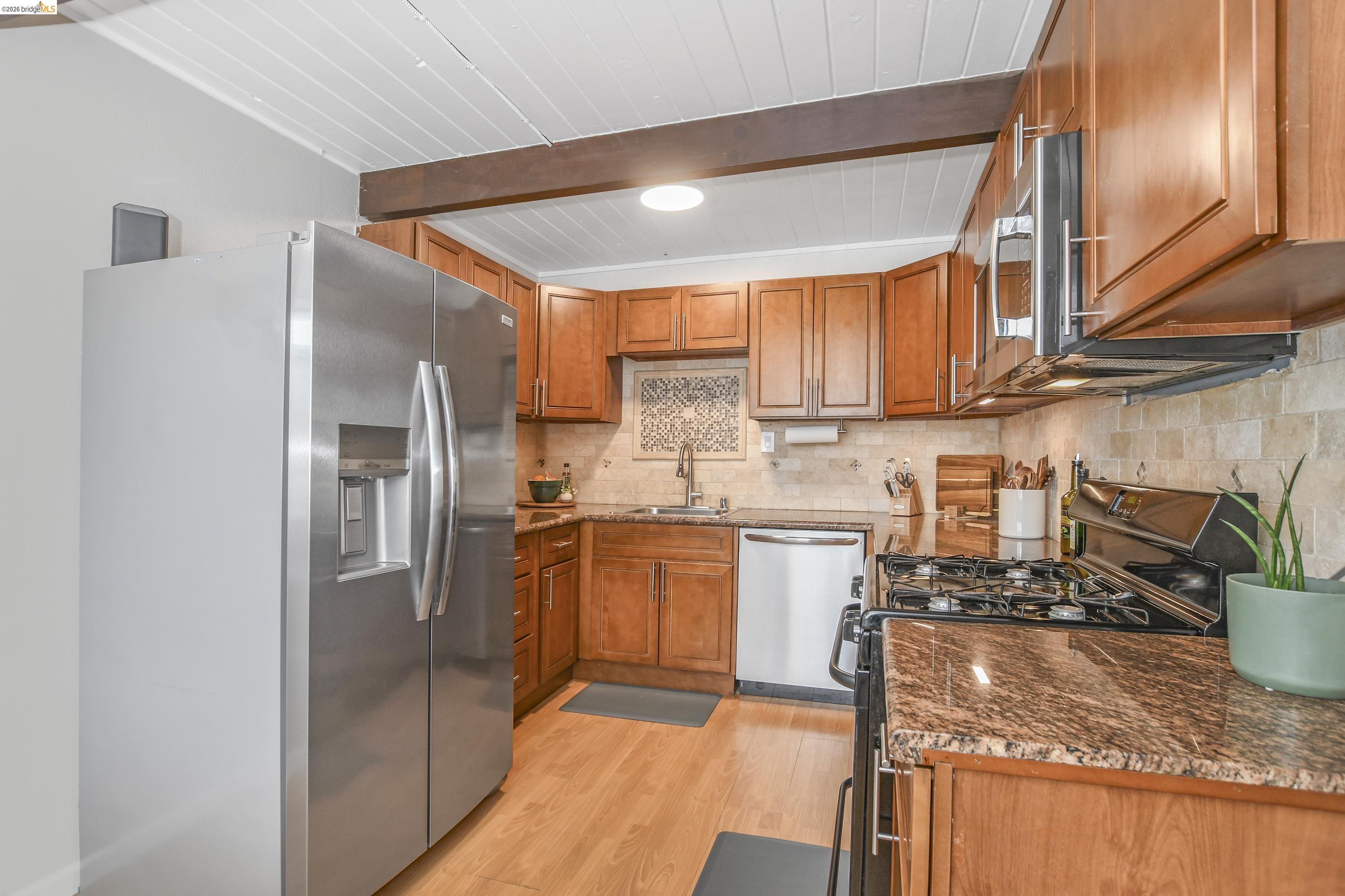 37 Beach Drive Bay Point, CA 94565 - Photo 9 of 33 a kitchen with stainless steel appliances granite countertop a refrigerator a sink dishwasher a stove and white countertops with wooden floor