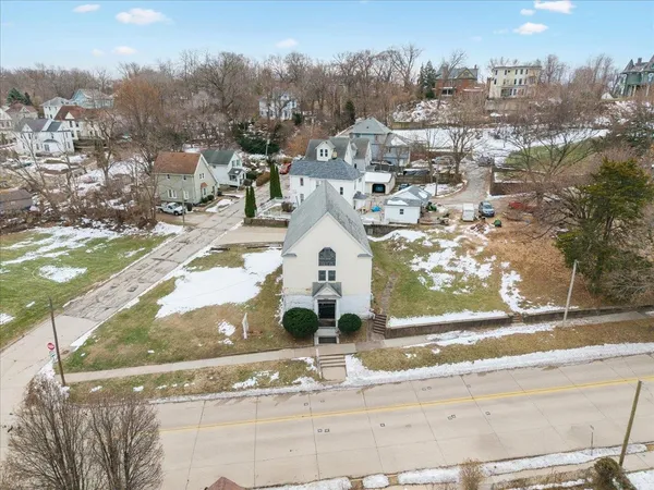a view of a white house with a yard and lawn chairs