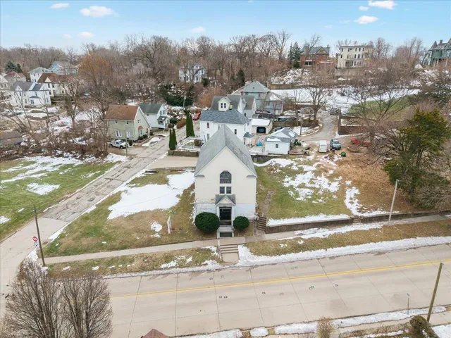 a view of a white house with a yard and lawn chairs