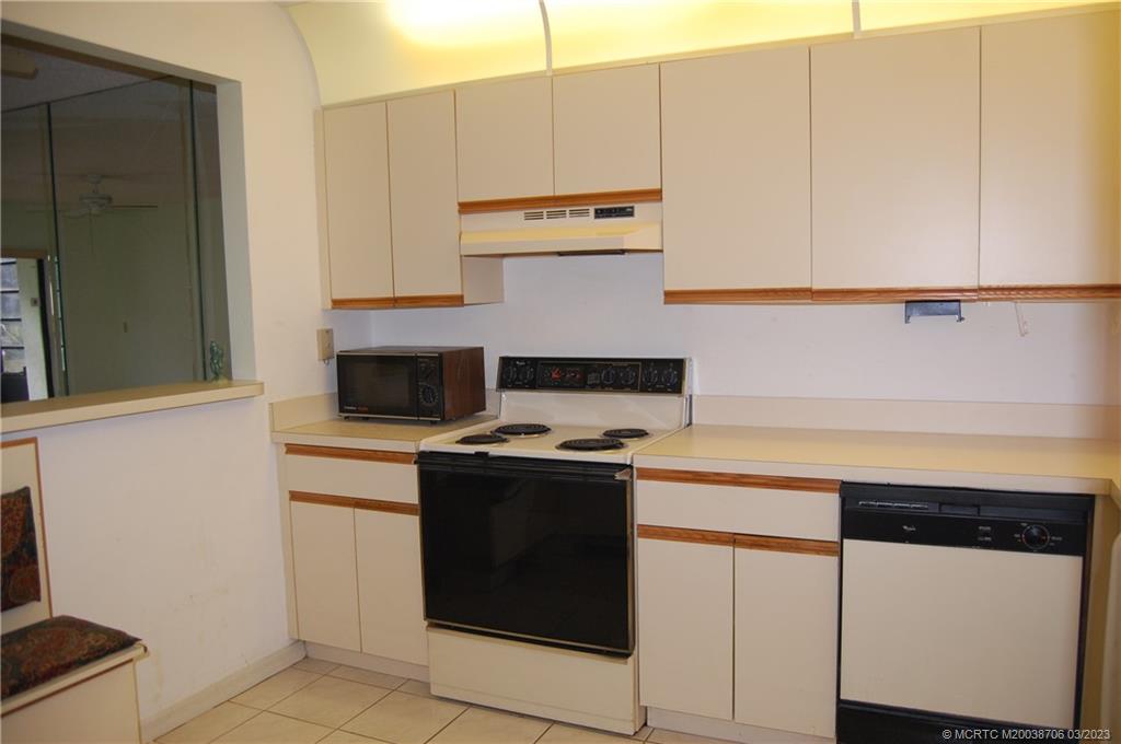 1881 Southwest Palm City Road, Unit H201 Stuart, FL 34994 - Photo 12 of 33 a kitchen with cabinets and appliances