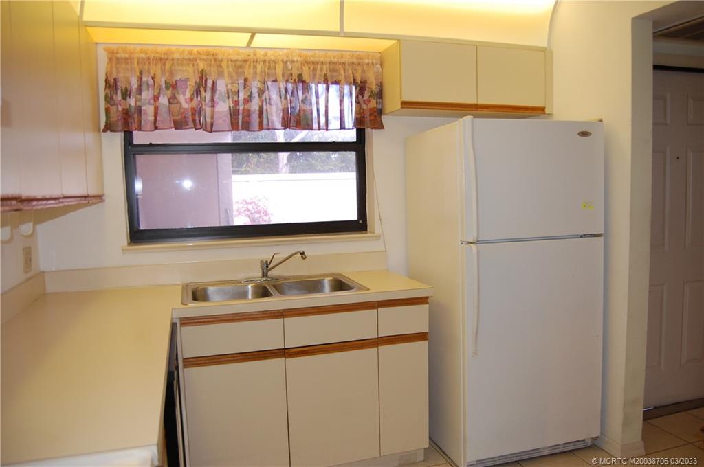 1881 Southwest Palm City Road, Unit H201 Stuart, FL 34994 - Photo 13 of 33 a bathroom with a sink and a refrigerator