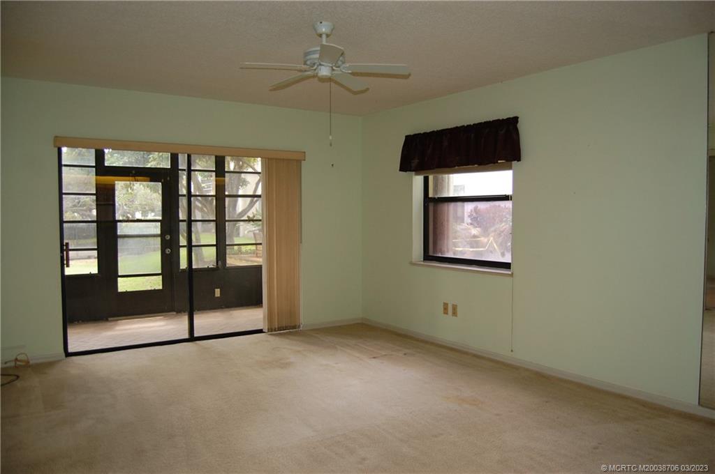 1881 Southwest Palm City Road, Unit H201 Stuart, FL 34994 - Photo 9 of 33 an empty room with windows and fan