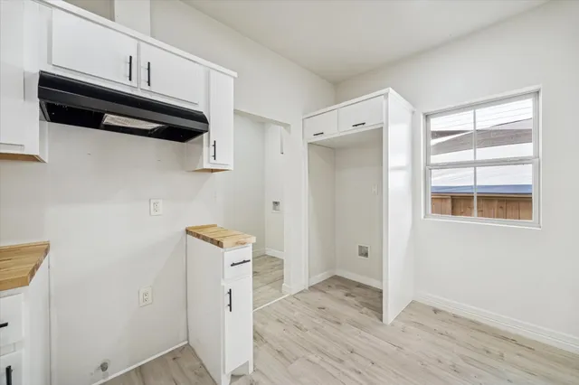 a view of a storage and utility room with wooden floor