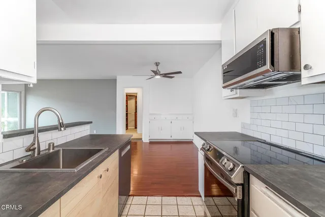 a kitchen with stainless steel appliances granite countertop a sink and a microwave