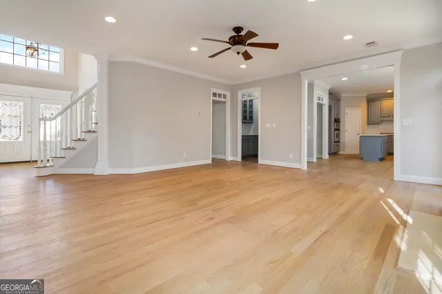 an empty room with wooden floor and windows