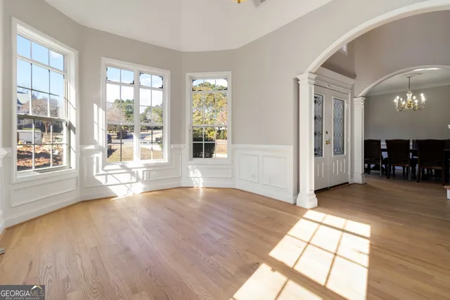 an empty room with wooden floor and windows