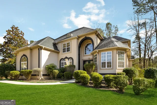a front view of a house with a garden and plants