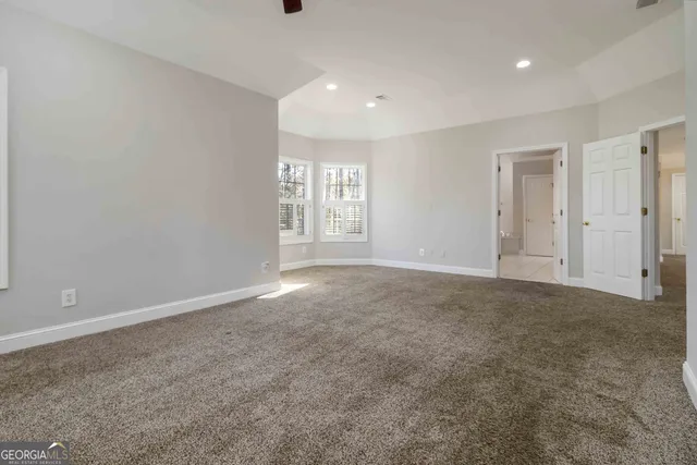 an empty room with closet and fan