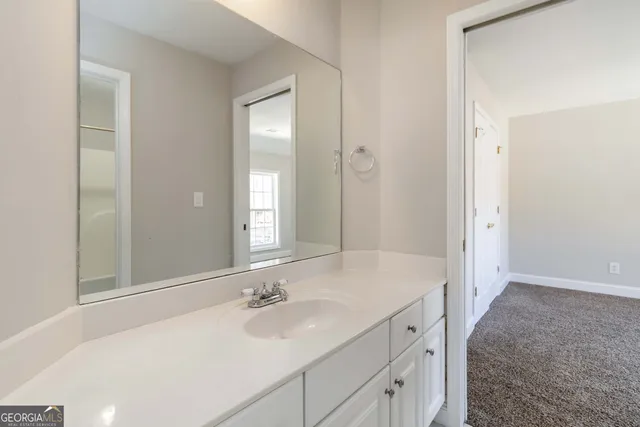 a bathroom with a sink vanity mirror and toilet
