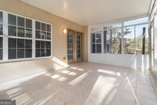 a front view of a multi story residential apartment building with yard and car parked