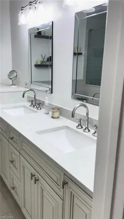 a bathroom with double vanity sink and a mirror