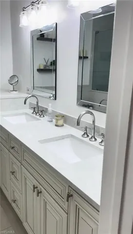 a bathroom with double vanity sink and a mirror
