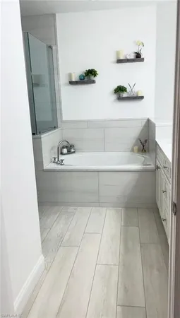 a bathroom with a bathtub sink and mirror