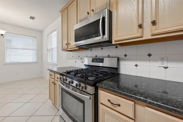 a kitchen with stainless steel appliances granite countertop a refrigerator sink and white cabinets