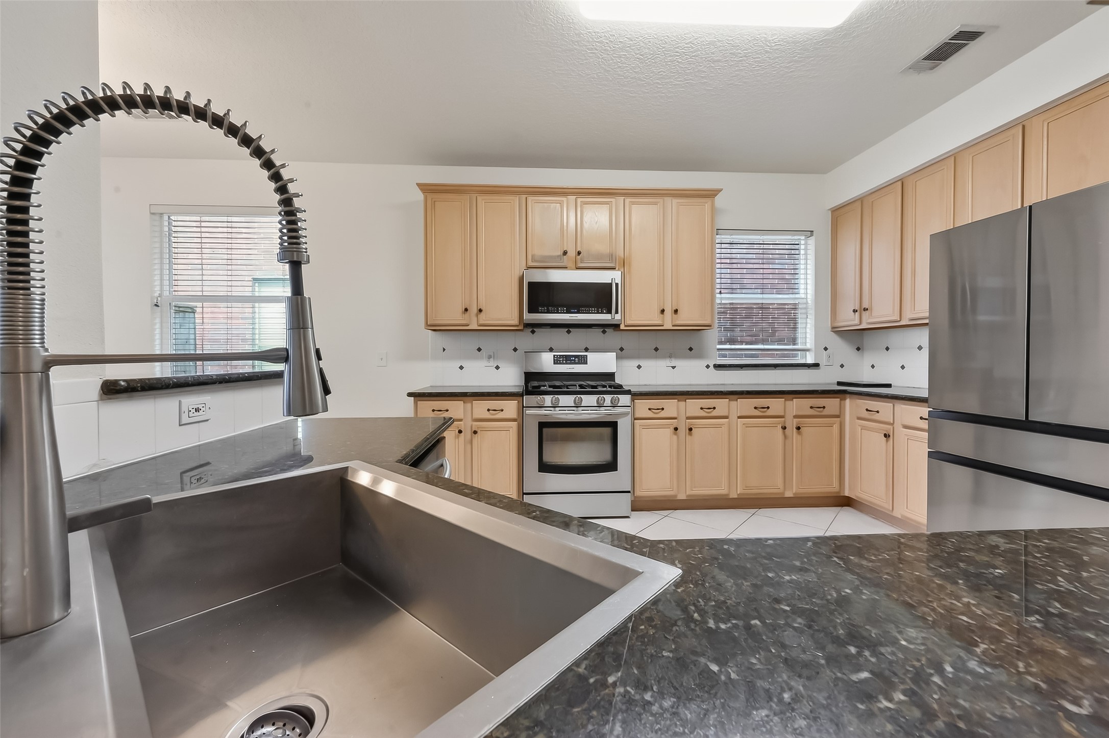 19715 Azalea Brook Way Houston, TX 77084 - Photo 16 of 48 a kitchen with stainless steel appliances granite countertop a stove a sink and a microwave