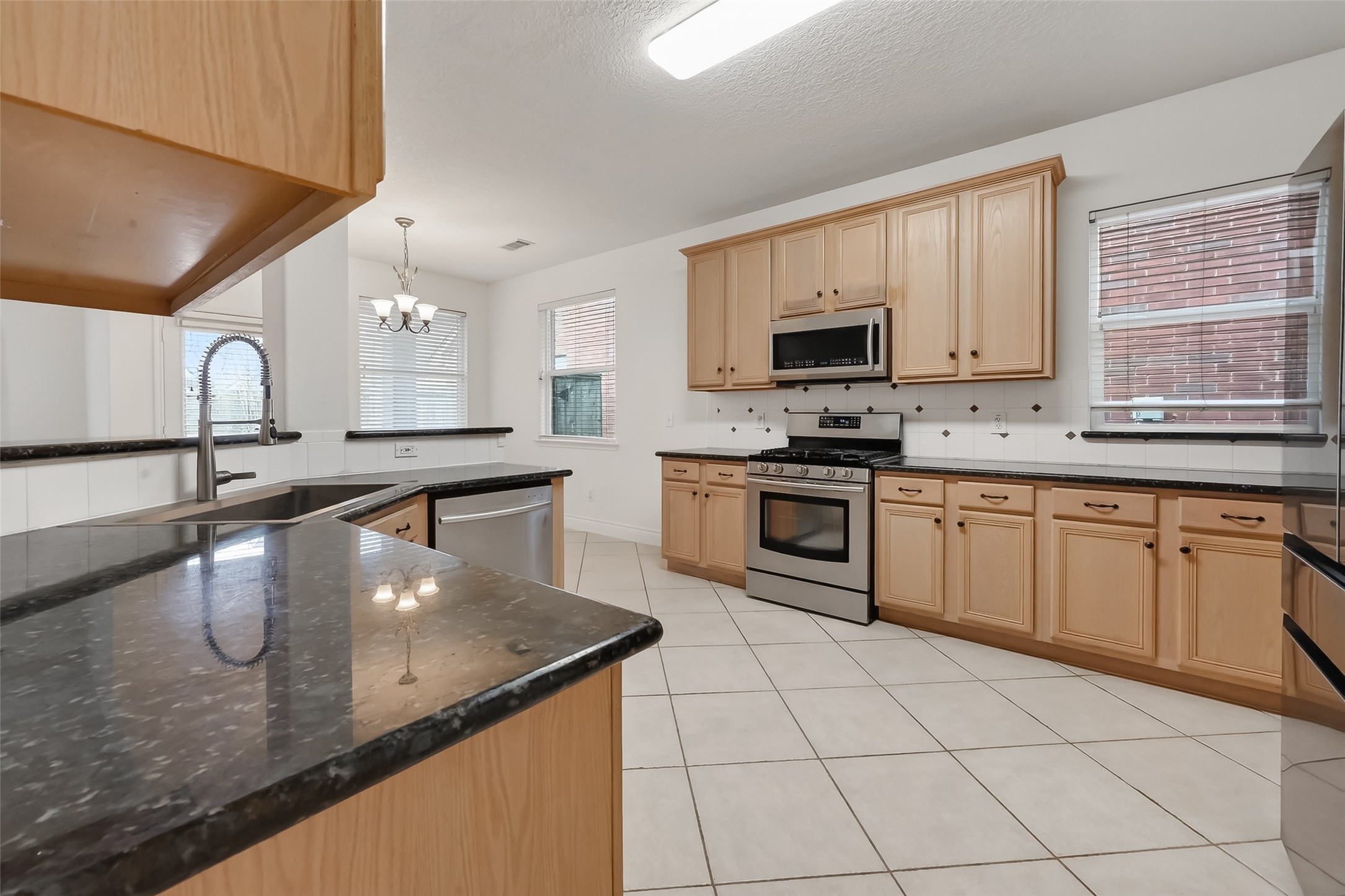 19715 Azalea Brook Way Houston, TX 77084 - Photo 17 of 48 a kitchen with stainless steel appliances granite countertop a sink stove and cabinets