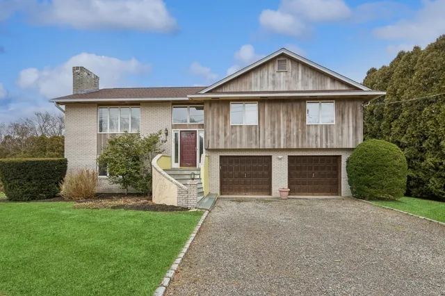 a front view of a house with a garden and yard