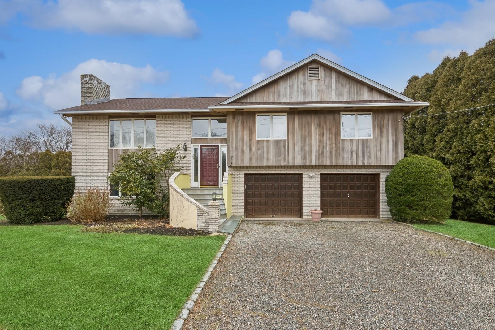 440 Pine Neck Road Southold, NY 11971 - Photo 1 of 21 a front view of a house with a garden and yard