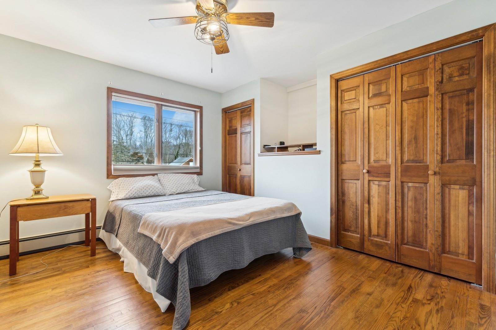 440 Pine Neck Road Southold, NY 11971 - Photo 11 of 21 a bedroom with a bed and a chandelier