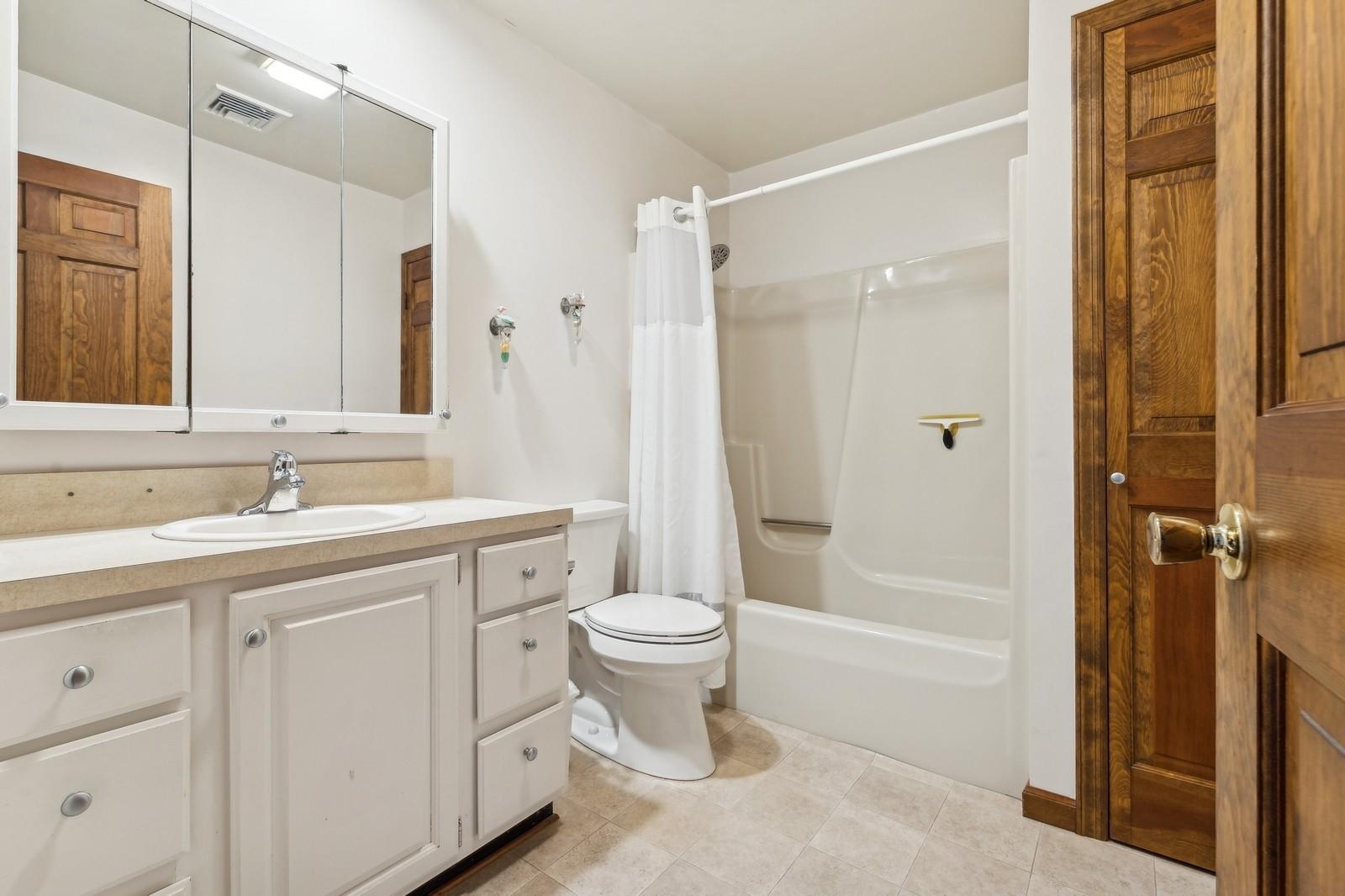 440 Pine Neck Road Southold, NY 11971 - Photo 13 of 21 a bathroom with a double vanity sink toilet and shower