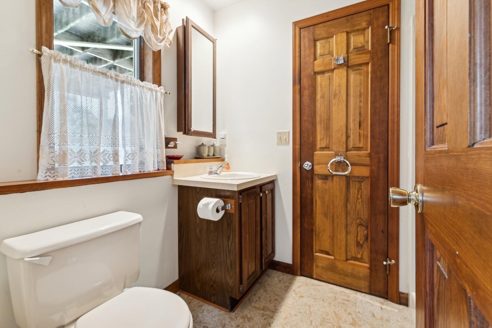 440 Pine Neck Road Southold, NY 11971 - Photo 16 of 21 a bathroom with a toilet a sink and a mirror