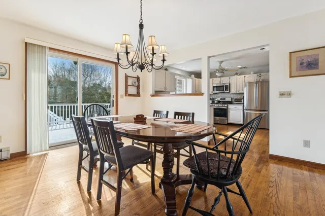 a view of a dining room with furniture a chandelier and wooden floor