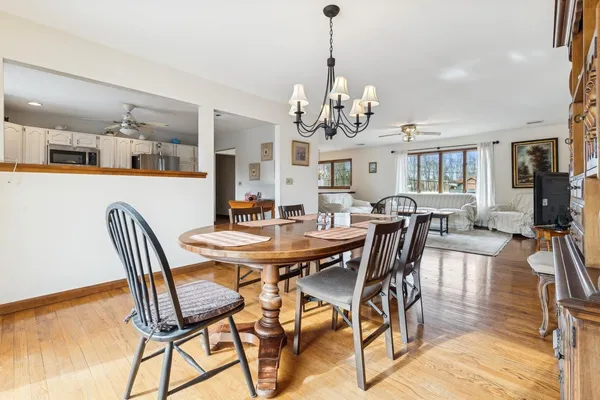 a view of a dining room with furniture a chandelier and wooden floor