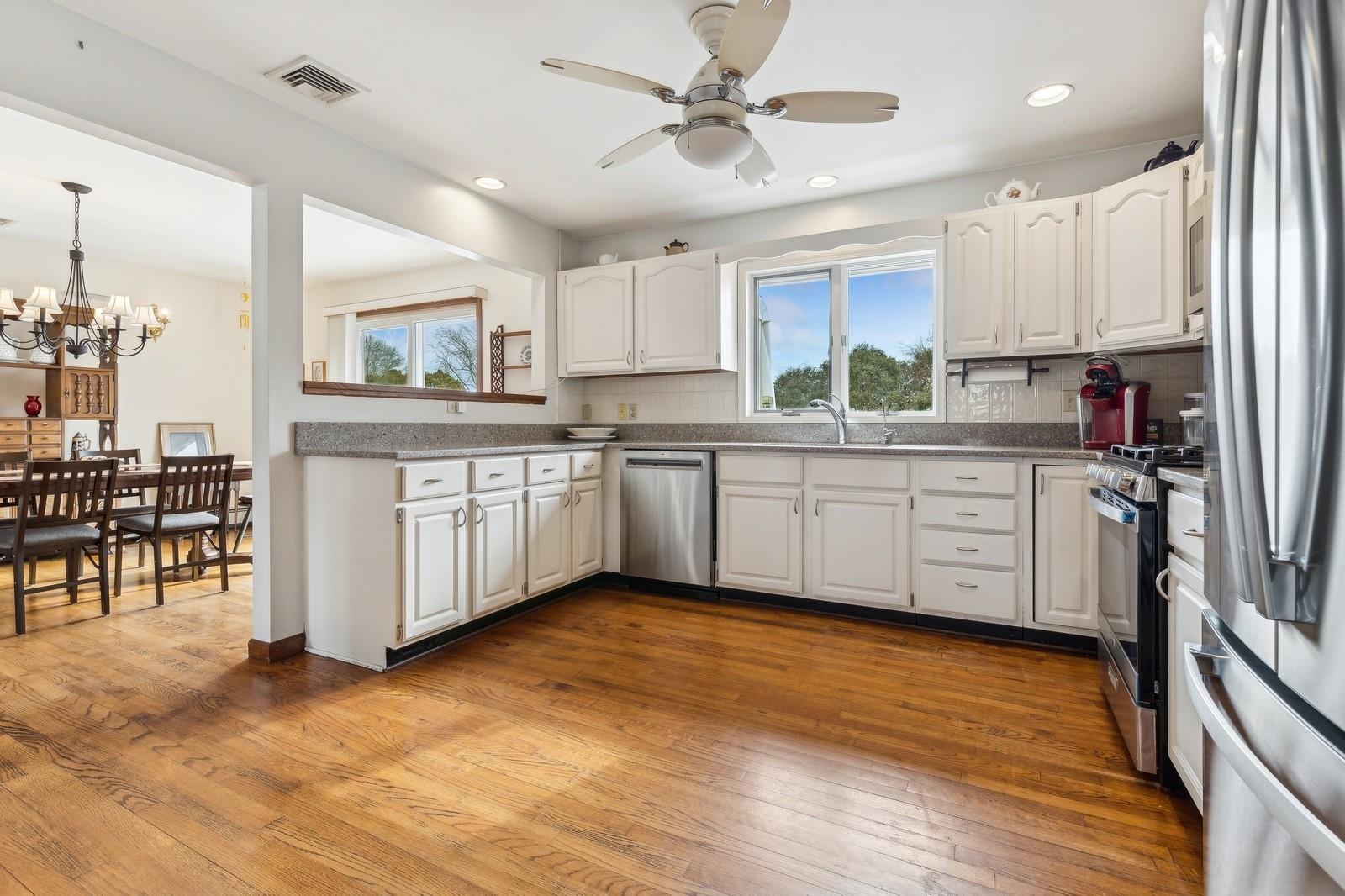 440 Pine Neck Road Southold, NY 11971 - Photo 7 of 21 a kitchen with stainless steel appliances granite countertop a sink cabinets and wooden floor