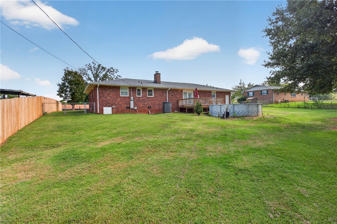118 Bryson Road Anderson, SC 29625 - Photo 24 of 36 An expansive green lawn sits beside a brick home with an elevated rear deck.