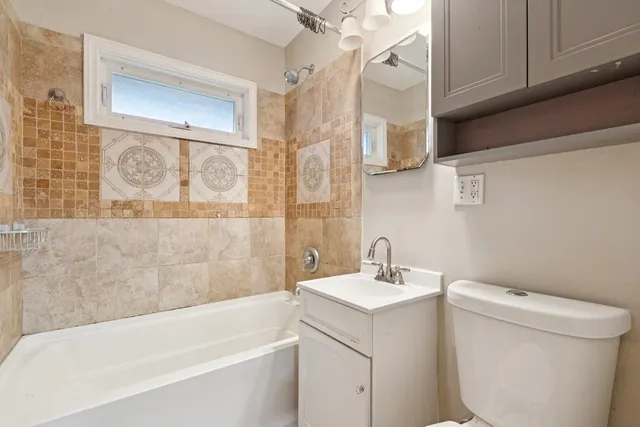 a bathroom with a toilet a sink and mirror