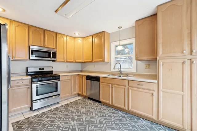 a kitchen with stainless steel appliances granite countertop a stove a sink and a microwave