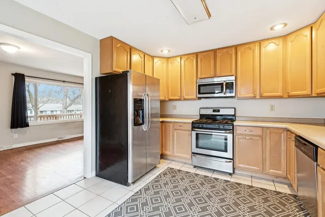 a kitchen with granite countertop a refrigerator and a stove top oven