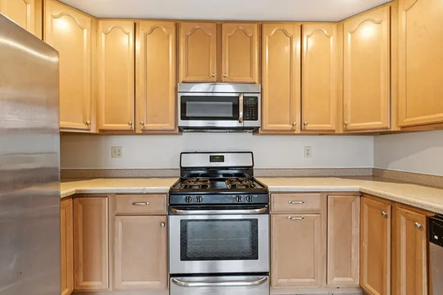 a kitchen with granite countertop cabinets stainless steel appliances and a window