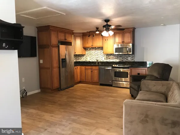 a kitchen with stainless steel appliances granite countertop a refrigerator a stove and a sink